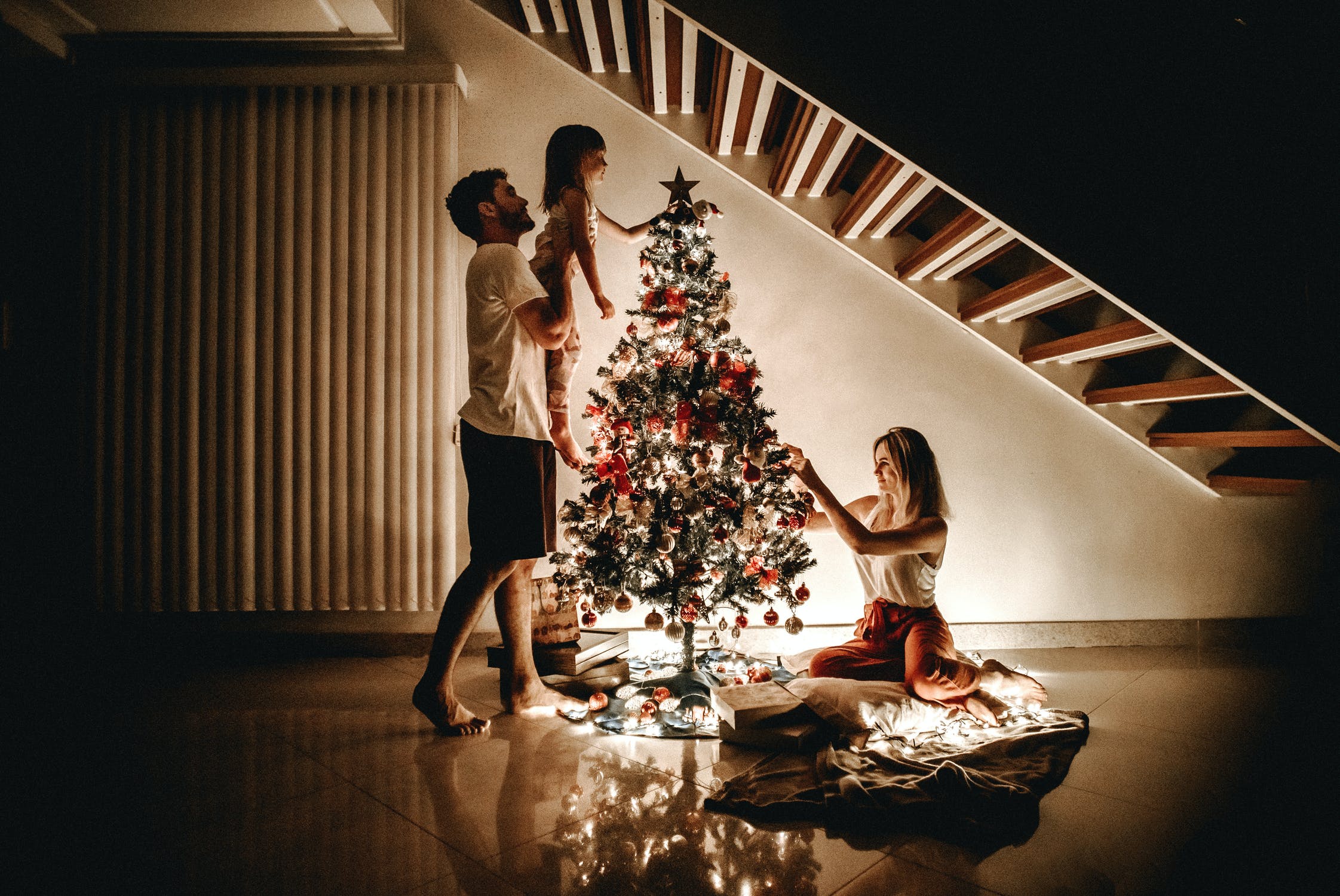 familj klär julgranen